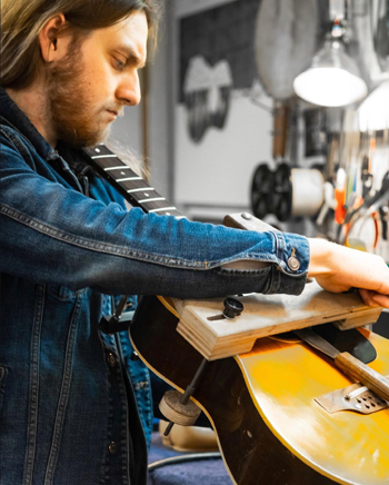 Guitar Service Center - Our repairman expertly repairs a guitar